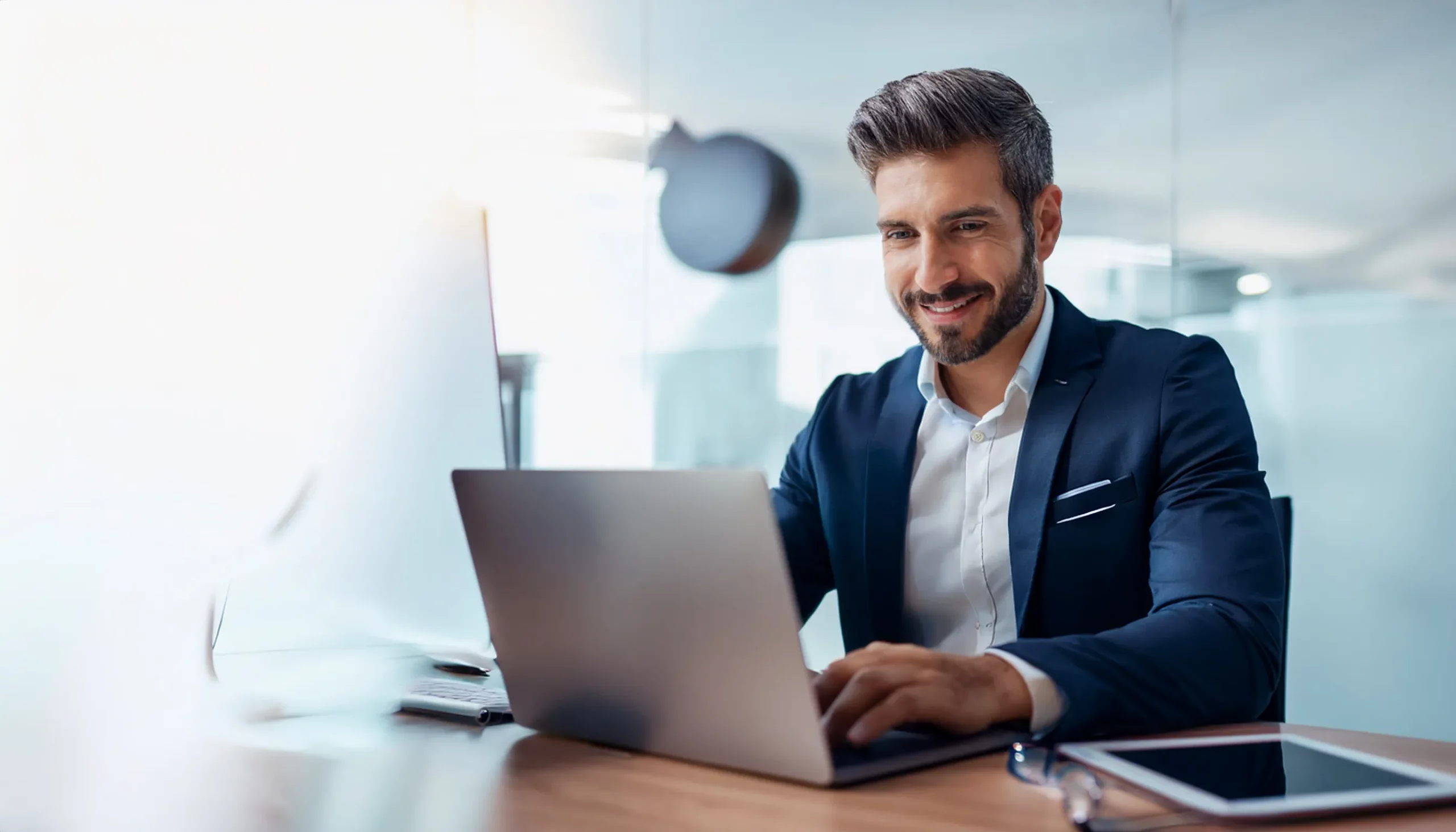 Smiling Australian man working at computer in modern Melbourne office